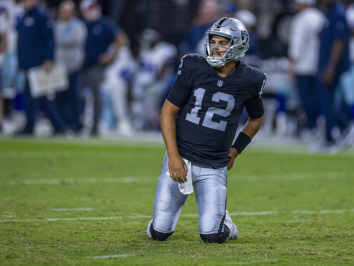 Raiders quarterback Aidan O'Connell (12) looks up from the turf after taken down by Dallas Cowb ...