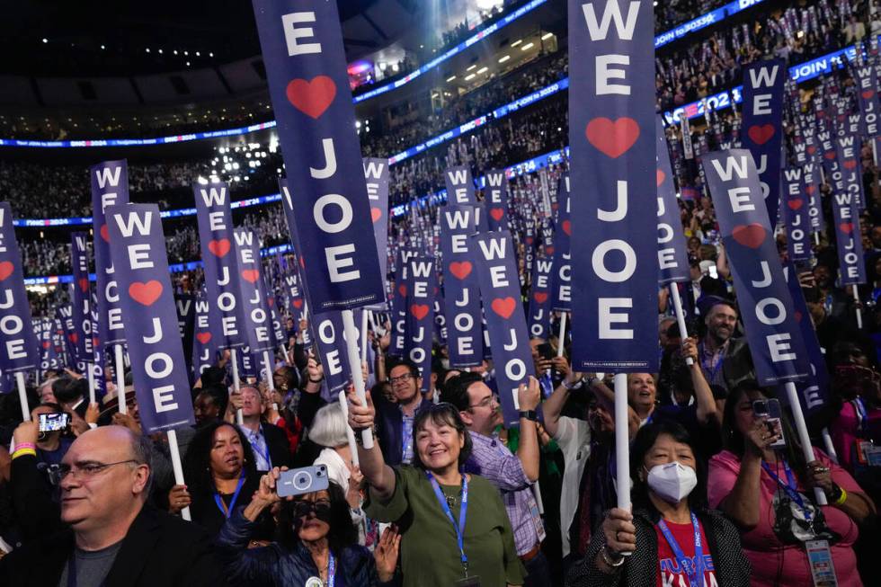 Delegates cheer as President Joe Biden speaks during the first day of Democratic National Conve ...