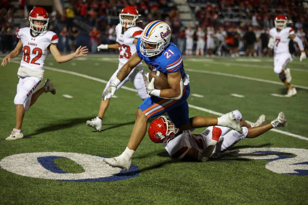 Bishop Gorman running back Jonathan Coar (21) runs through an attempted Kahuku tackle during th ...