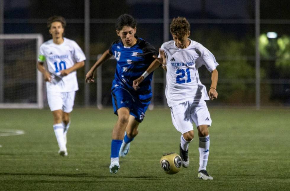 Sierra Vista midfielder Sevastian Suarez (21) and Basic sophomore Malcolm Sady Kennedy (13) com ...