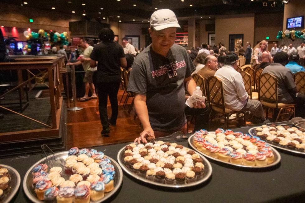 Tuan Nguyen, a staff member of over 25 years, reaches for a cupcake during Boulder Station&#x20 ...