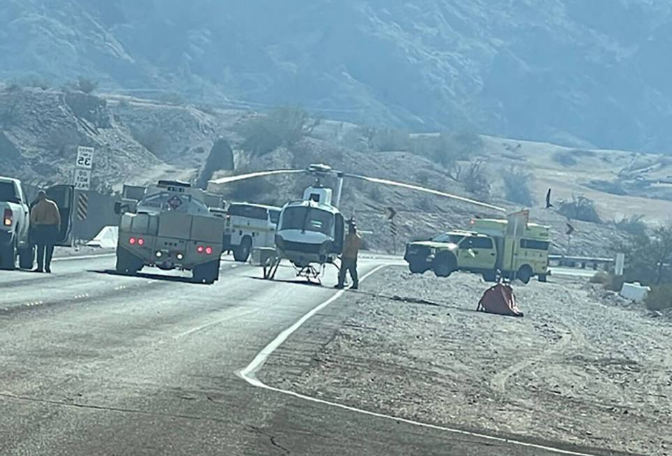 Firefighters, a helicopter and other equipment work a brush fire between Laughlin and Bullhead ...