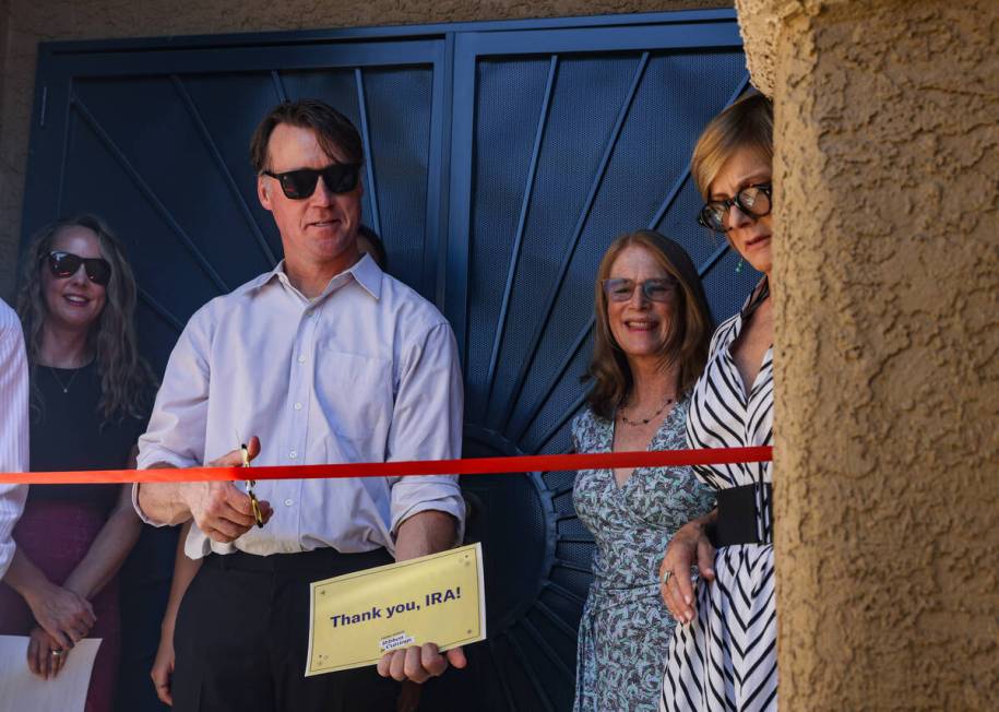 William Huggins cuts the ribbon to his home at an event highlighting the use of Inflation Reduc ...