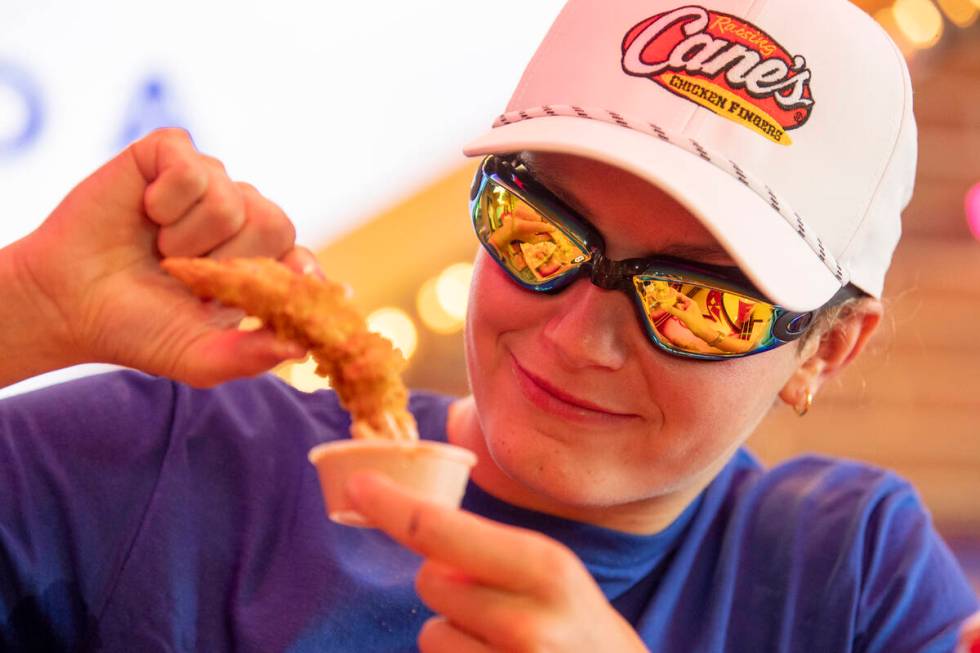 Olympic medalist Katie Grimes dunks a chicken finger in sauce during a promotional homecoming & ...