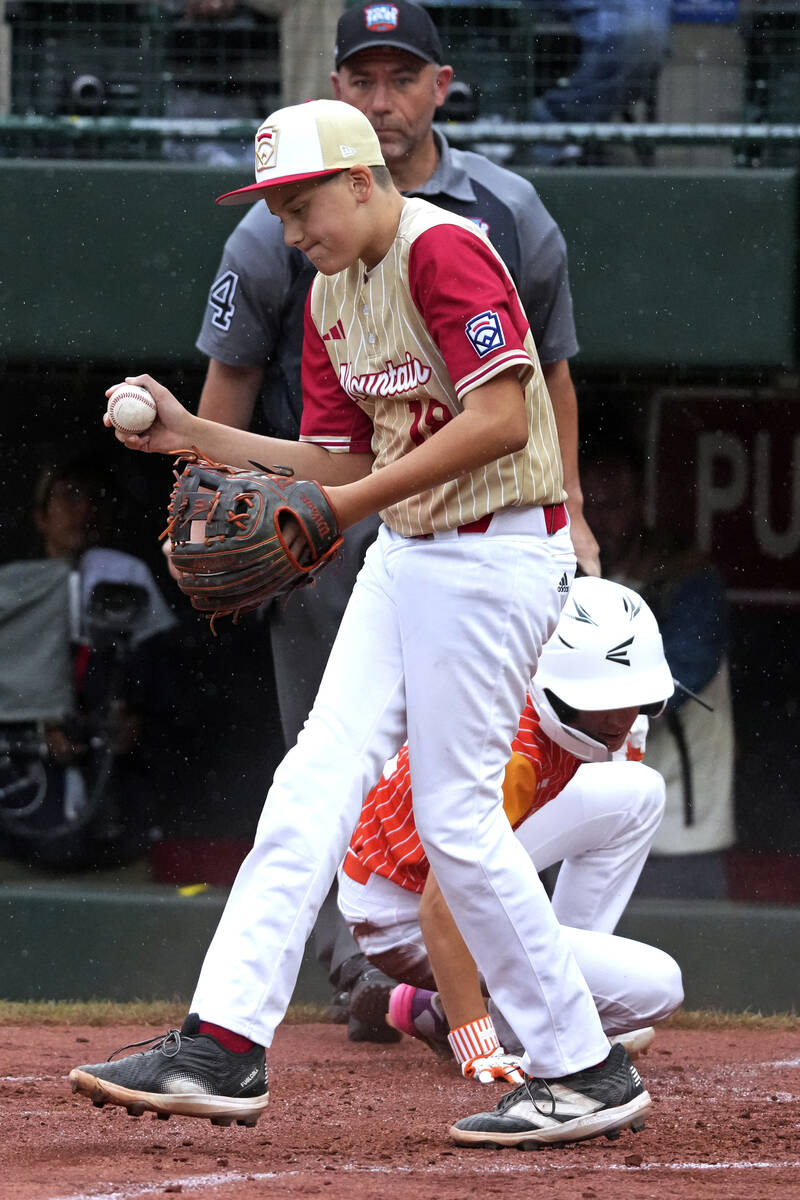 Henderson, Nev.'s Wyatt Erickson, center, walks back to the mound after being unable to tag out ...