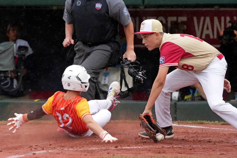 Boerne, Texas' Gage Steubing (12) scores past Henderson, Nev.'s Wyatt Erickson (18) on a single ...