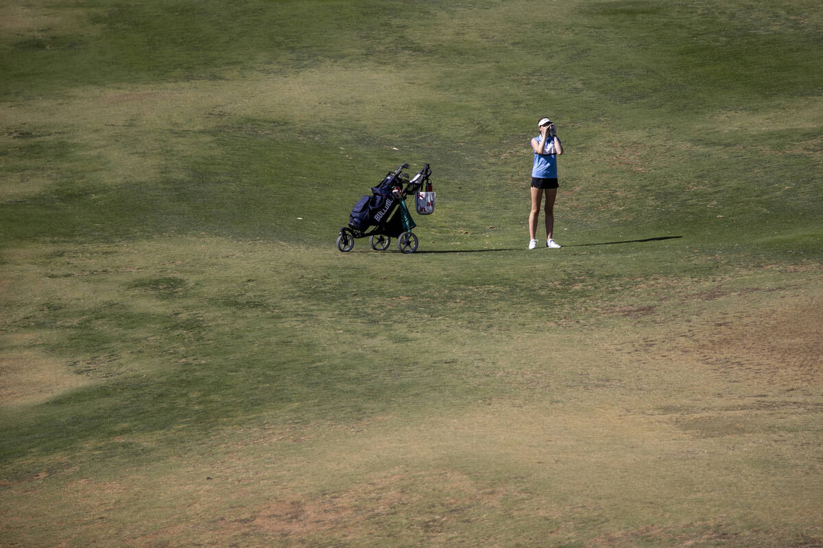 Centennial’s Mia Meyers uses a rangefinder during the 5A Desert League girls golf match ...