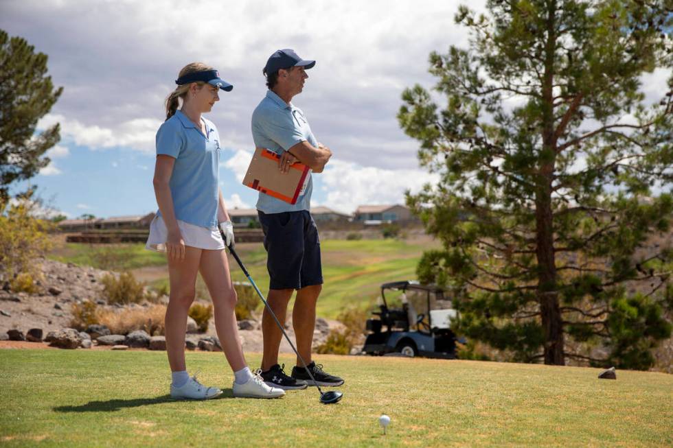 Liberty’s Emma Kirschner, left, looks down the course with Head Coach Blake Parke, right ...