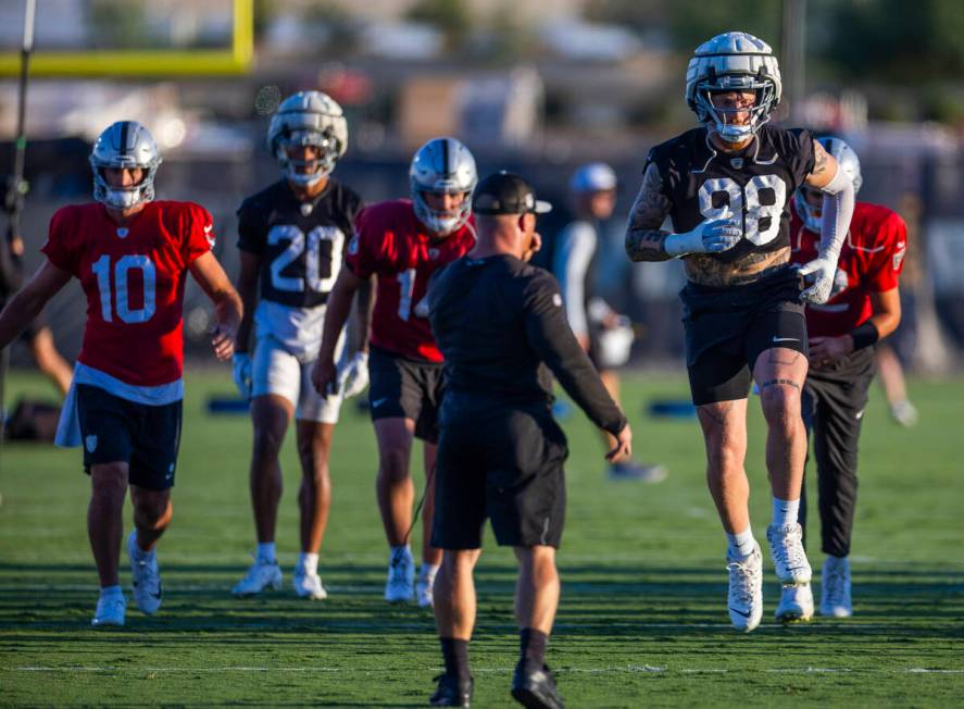 Raiders defensive end Maxx Crosby (98) catches some air during warm ups at practice in the Inte ...