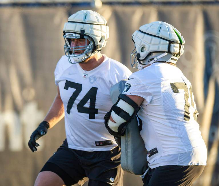 Raiders offensive tackle Kolton Miller (74) runs a drill with guard Jackson Powers-Johnson (70) ...