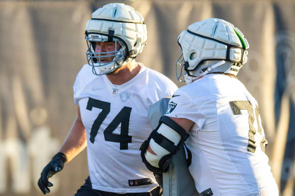 Raiders offensive tackle Kolton Miller (74) runs a drill with guard Jackson Powers-Johnson (70) ...