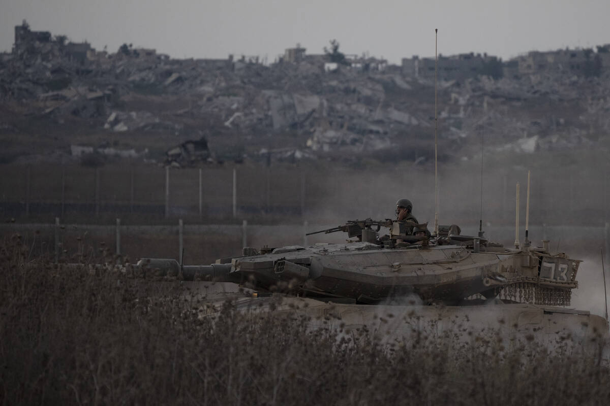 Israeli soldiers move on the top of a tank near the Israeli-Gaza border, as seen from southern ...