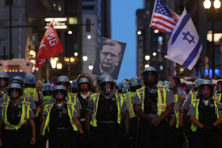 Police stand between demonstrators of differing viewpoints outside Accenture Tower, 500 W. Madi ...