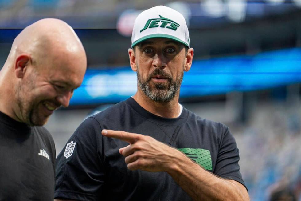 New York Jets quarterback Aaron Rodgers, right, gestures toward defensive line coach Aaron Whit ...