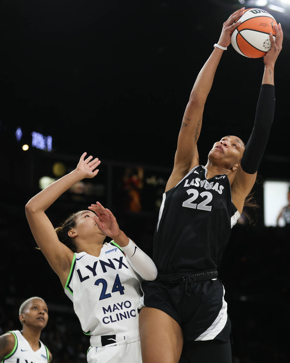 Las Vegas Aces center A'ja Wilson (22) snags a rebound over Minnesota Lynx forward Napheesa Col ...