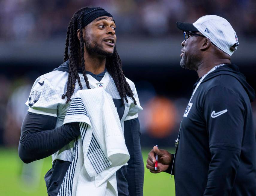 Raiders wide receiver Davante Adams (17) talks with a coach on the sidelines during an open pra ...