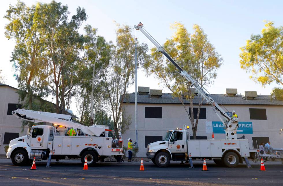 Workers from Clark County’s Public Works Department install one of the 12 new solar streetlig ...