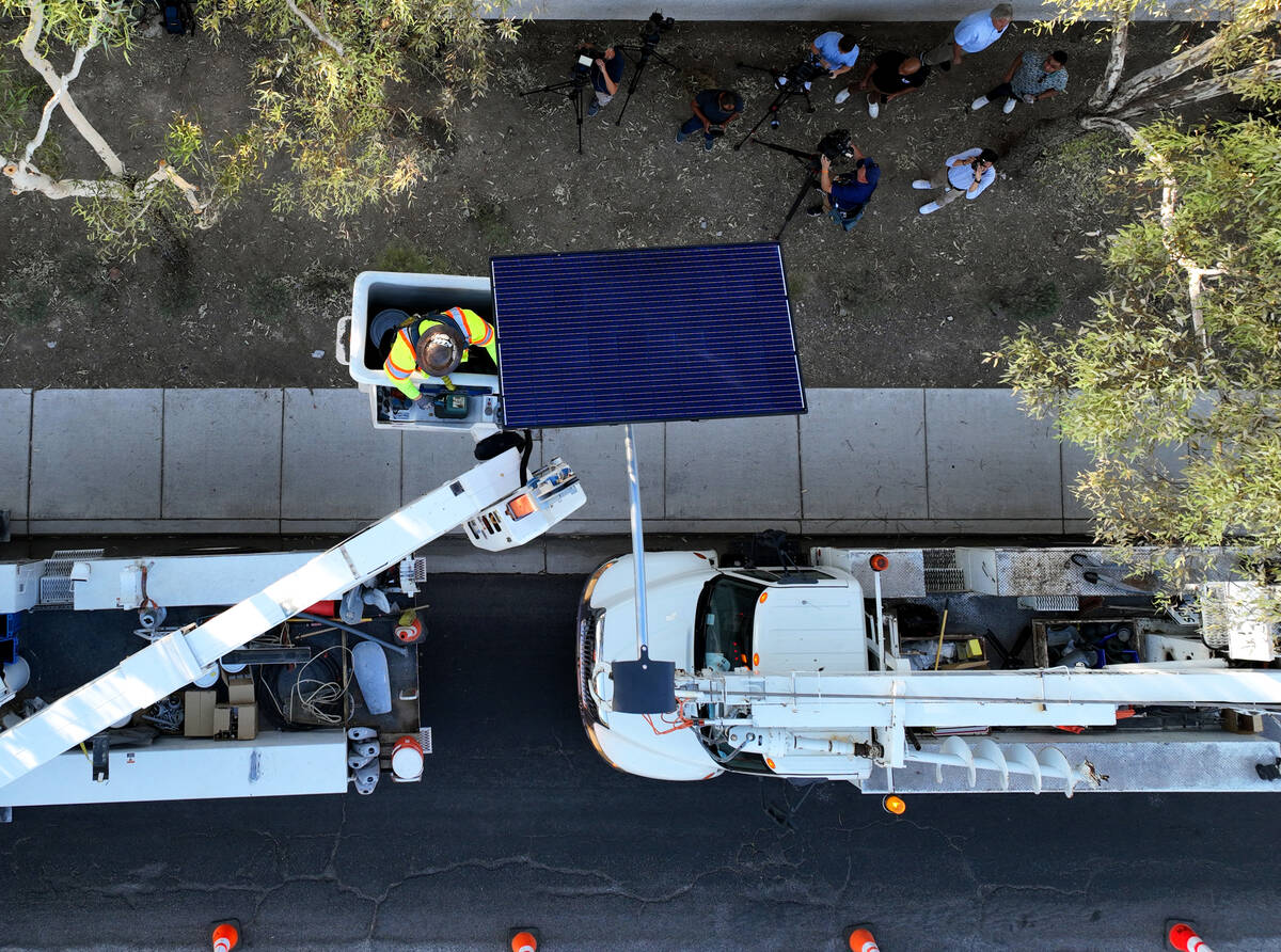 Workers from Clark County’s Public Works Department install one of the 12 new solar streetlig ...