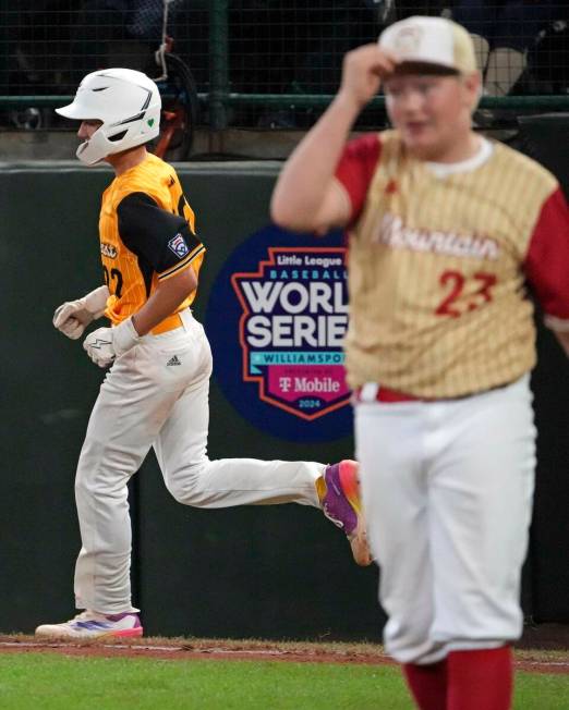 Lake Mary, Fla.'s Garrett Rohozen, left, rounds first base after hitting a solo home run off He ...