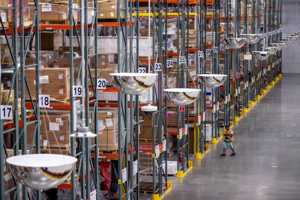 Workers walk through the rows of storage shelves at the new Aristocrat Gaming™ manufactu ...