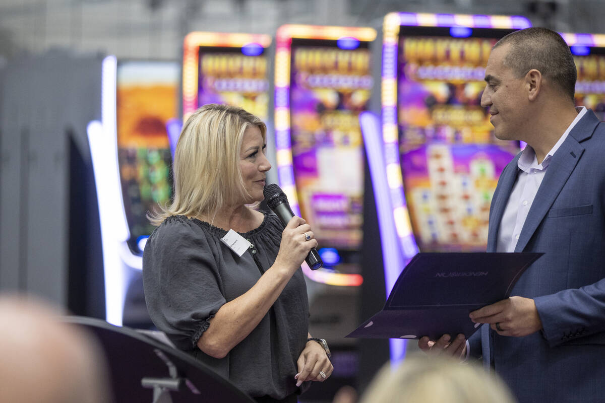 Henderson Mayor Michelle Romero, left, hands Aristocrat Gaming™ CEO Hector Fernandez, ri ...