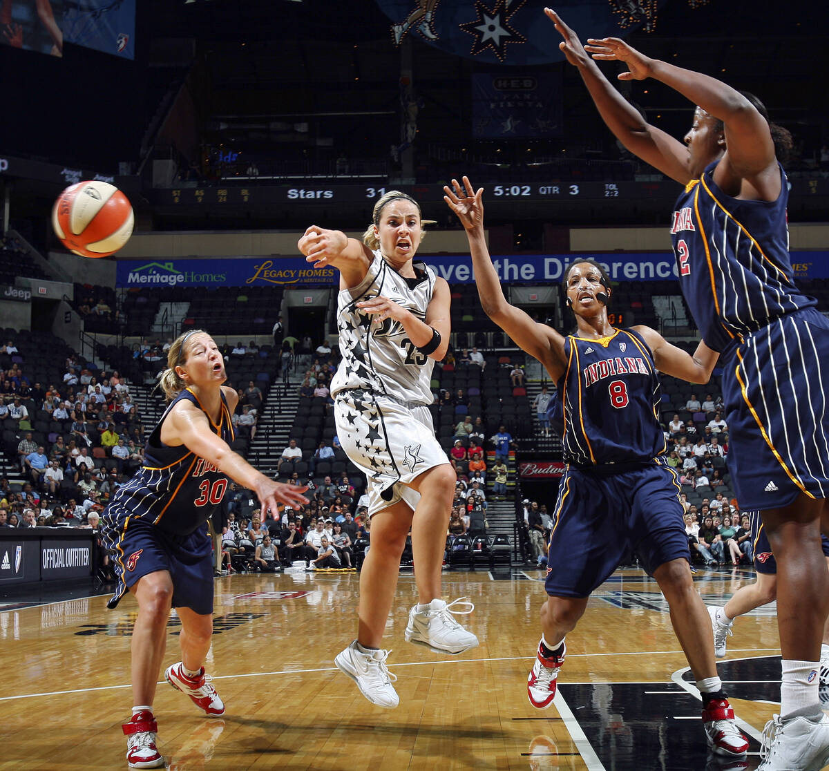 San Antonio Silver Stars' Becky Hammon, center, passes between Indiana Fever's Anna DeForge, Ta ...