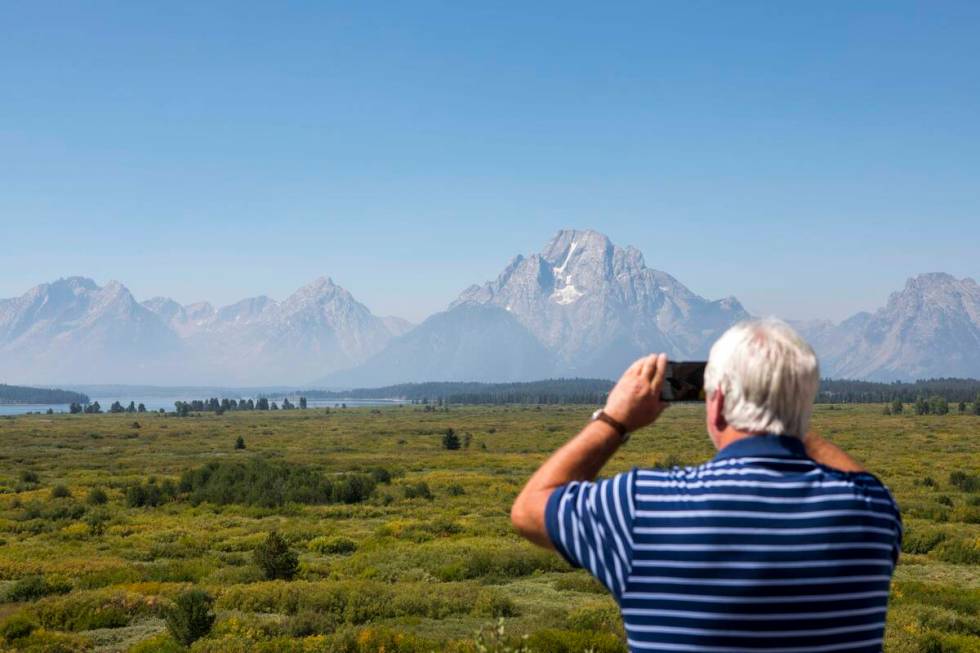 Steve Carringer of Tennessee takes a photo of the mountains at Jackson Lake Lodge, the site of ...