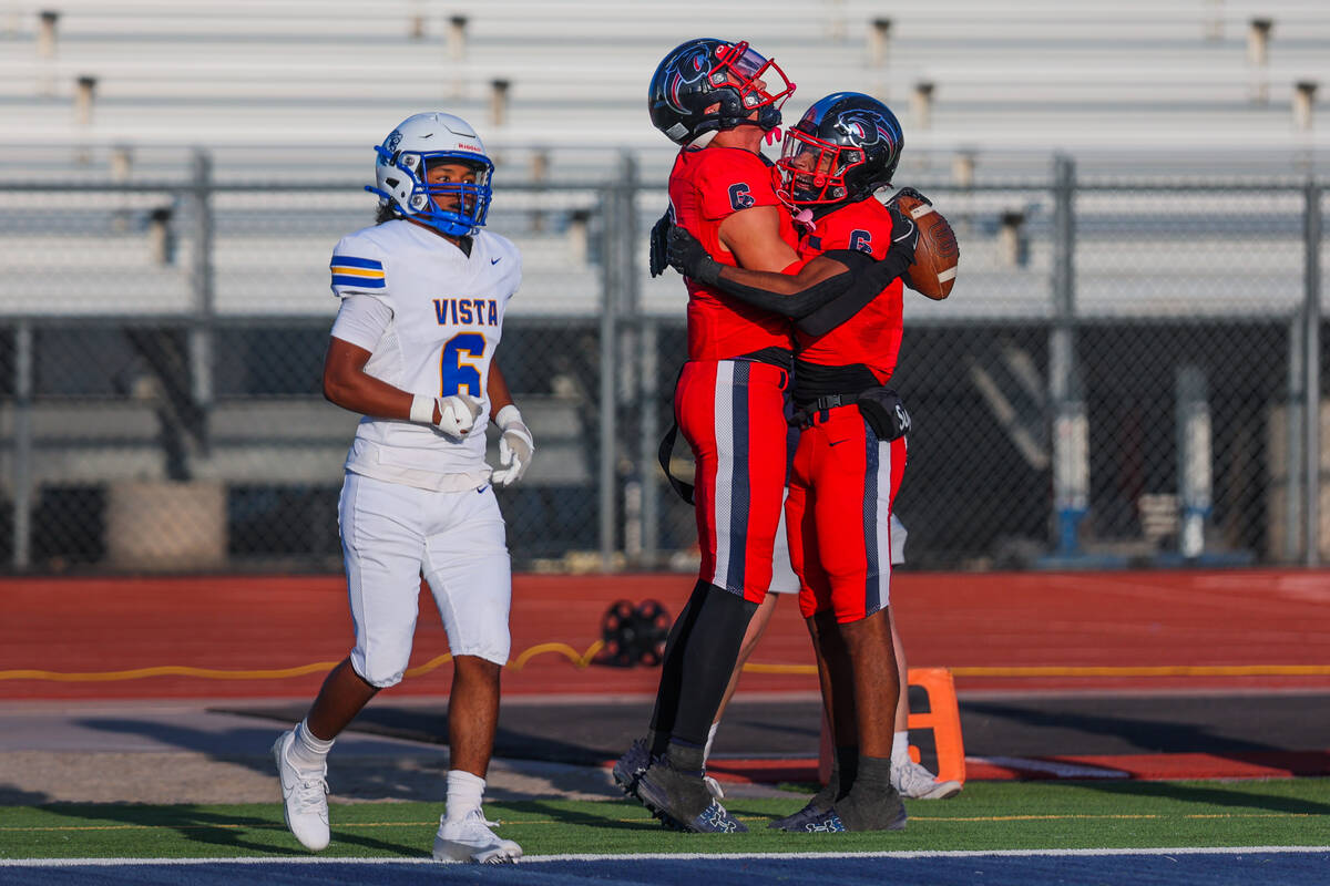 Coronado teammates Marquesion Floyde, right, and JJ Buchanan, middle, celebrate a touchdown by ...