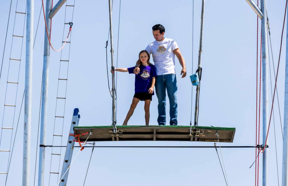 Renato Fernandes with his daughter Katalina standing atop of a platform on their backyard trape ...