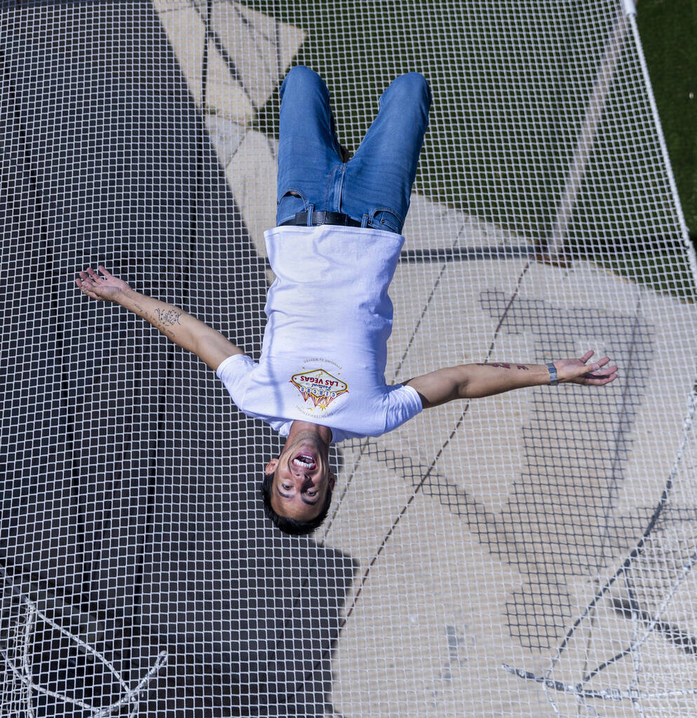 Renato Fernandes completes a backflip atop of the netting on his backyard trapeze on Saturday, ...