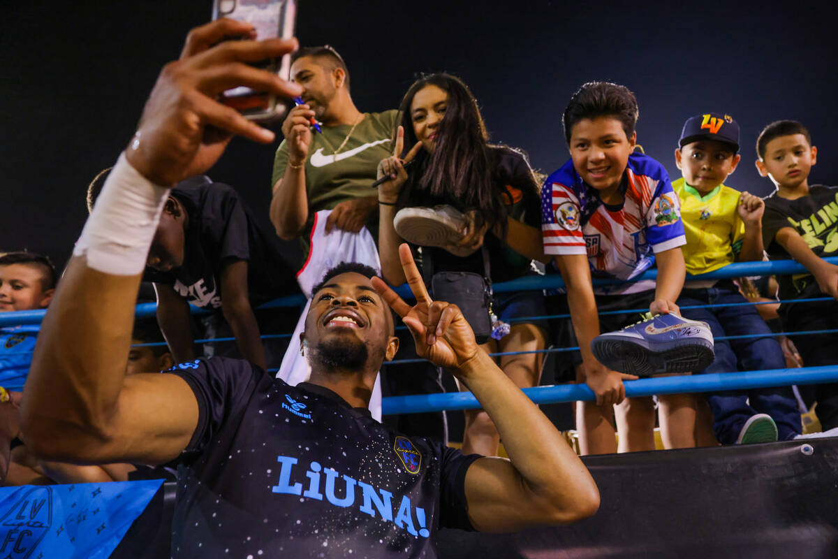 Lights FC forward Khori Bennett poses for photographs with fans following a soccer game betwee ...