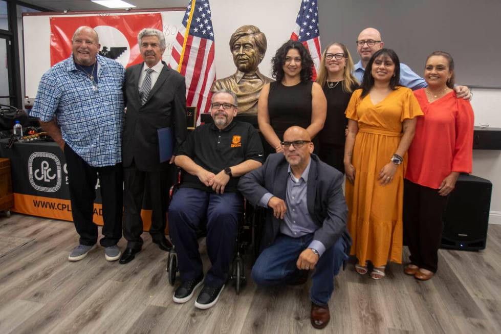 Members of Chicanos Por La Causa Nevada take a group photograph with the bust sculpture of Amer ...