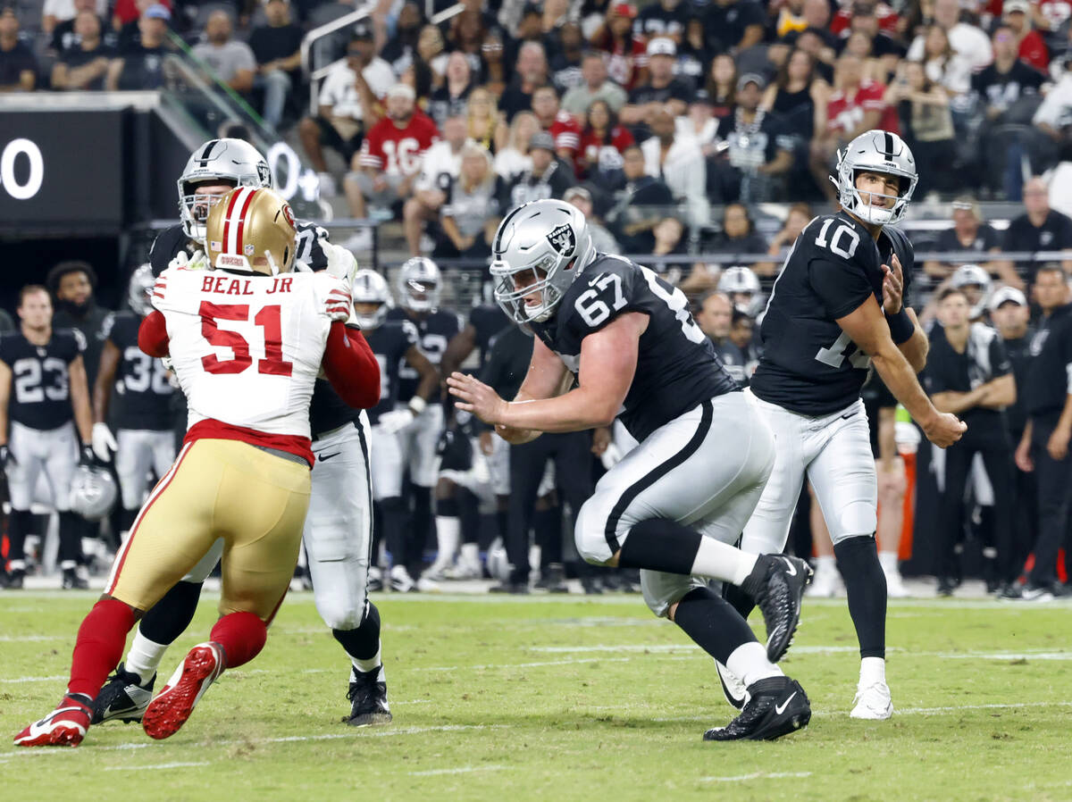 Raiders quarterback Nathan Peterman (10) watches his throw as Las Vegas Raiders center Will Put ...