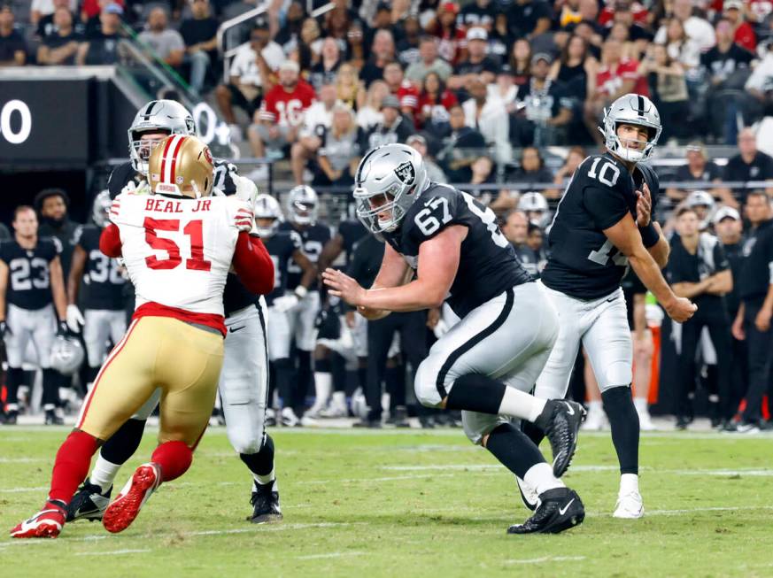 Raiders quarterback Nathan Peterman (10) watches his throw as Las Vegas Raiders center Will Put ...