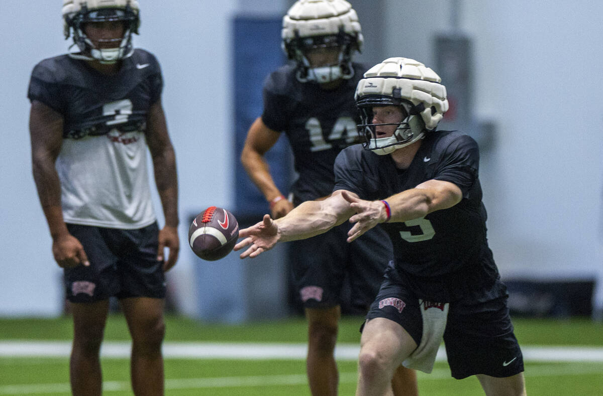 UNLV quarterback Matthew Sluka (3) tosses the ball to a running back during football practice a ...