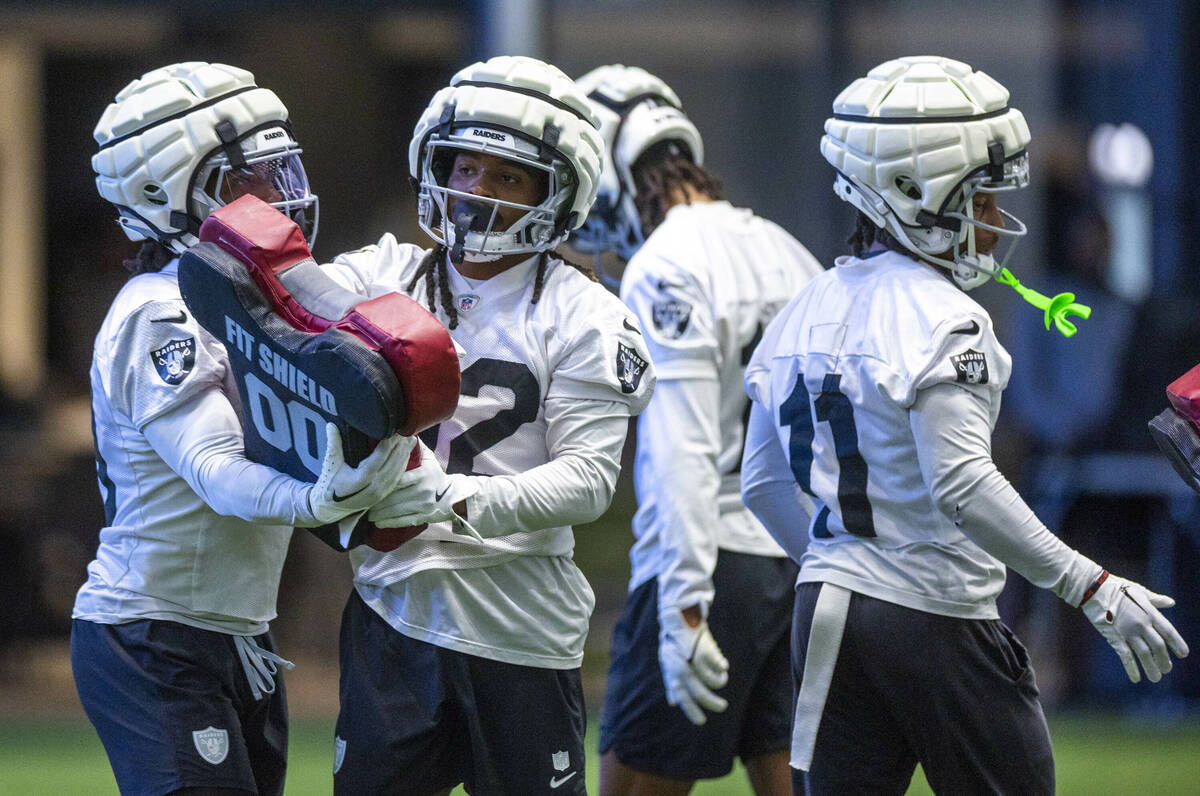 Raiders wide receiver DJ Turner (19) looks to wide receiver Tyreik McAllister (32) on a drill d ...