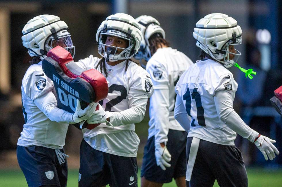 Raiders wide receiver DJ Turner (19) looks to wide receiver Tyreik McAllister (32) on a drill d ...