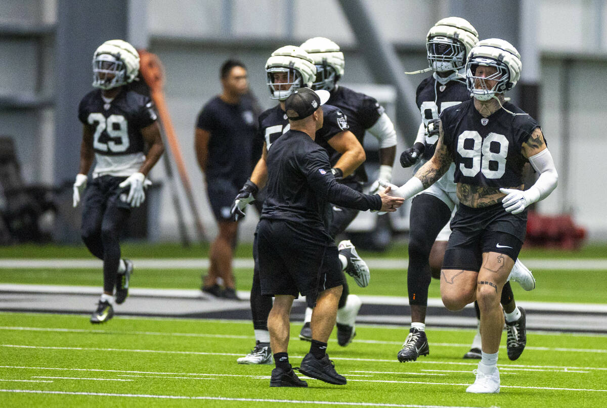 Raiders defensive end Max Crosby (98) greets Assistant Strength and Conditioning Coach Deuce Gr ...