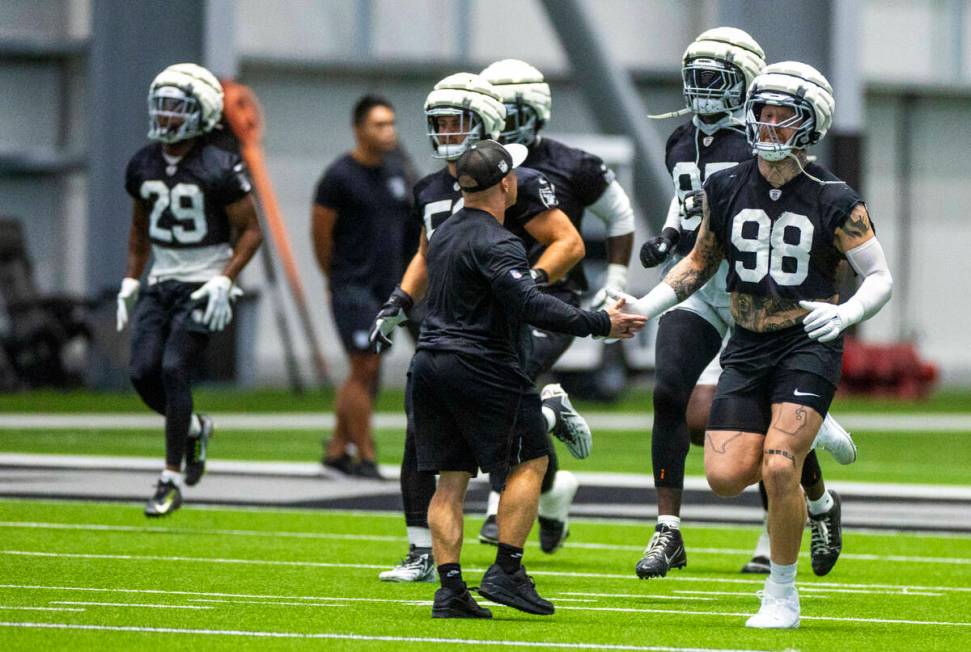 Raiders defensive end Max Crosby (98) greets Assistant Strength and Conditioning Coach Deuce Gr ...