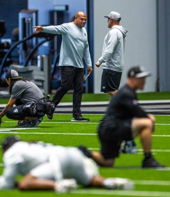 Raiders head coach Antonio Pierce chats with another coach during practice at the Intermountain ...