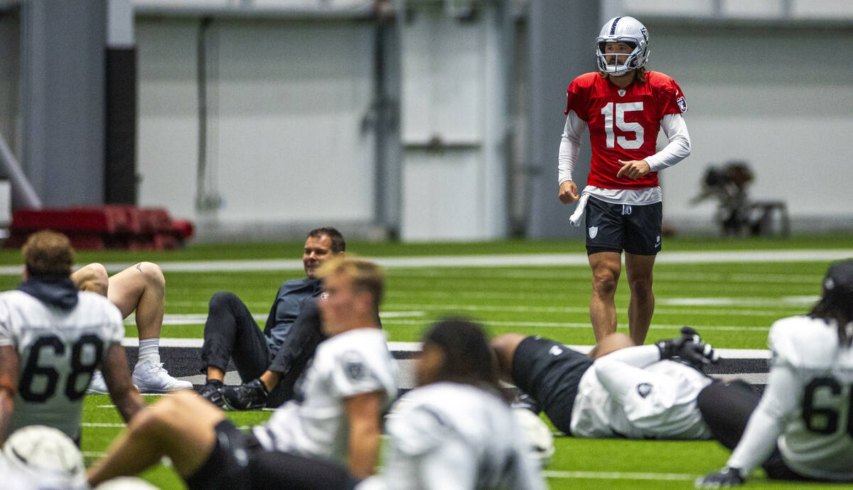 Raiders quarterback Gardner Minshew (15) runs over to teammates while stretching during practic ...