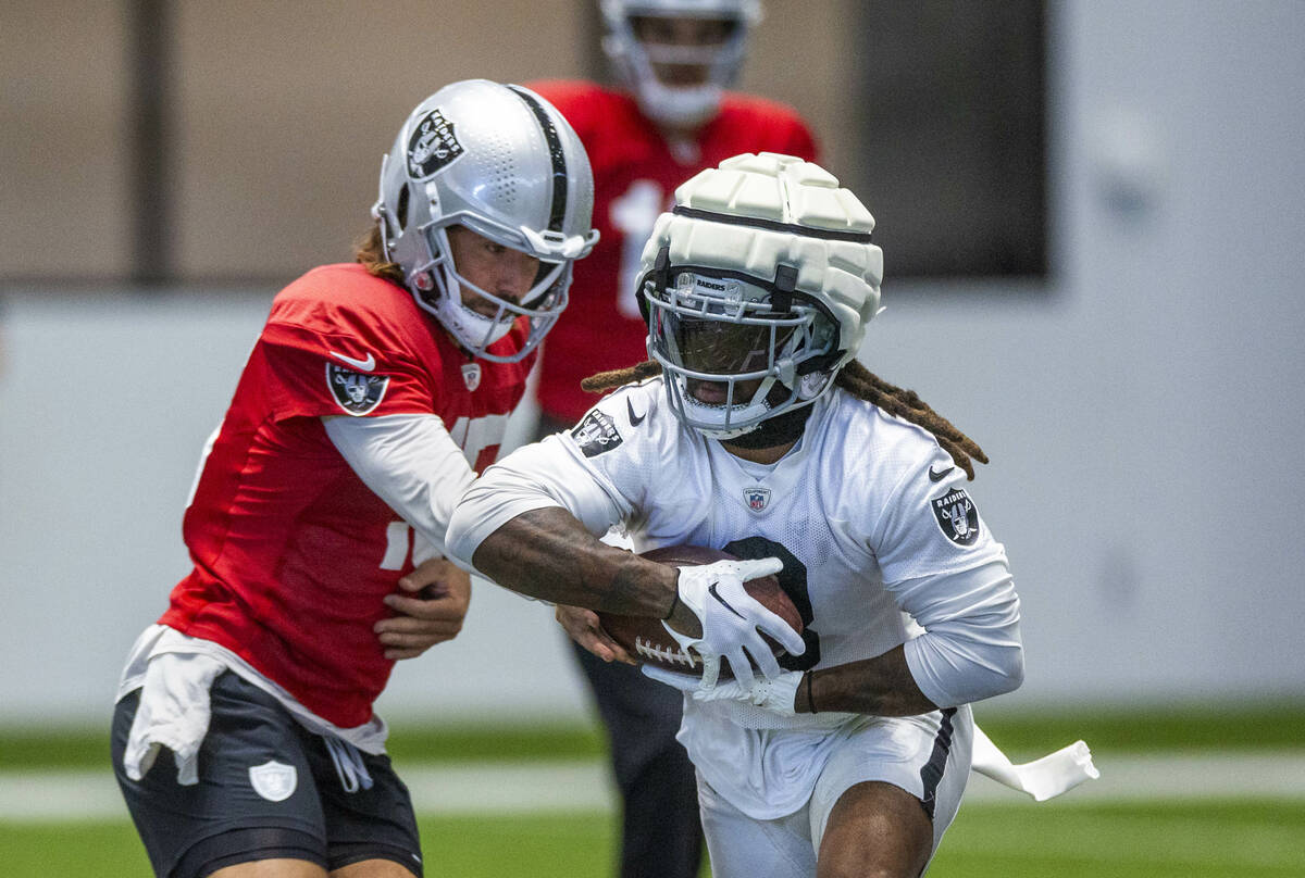 Raiders quarterback Gardner Minshew (15) hands off to Raiders running back Ameer Abdullah (8) d ...