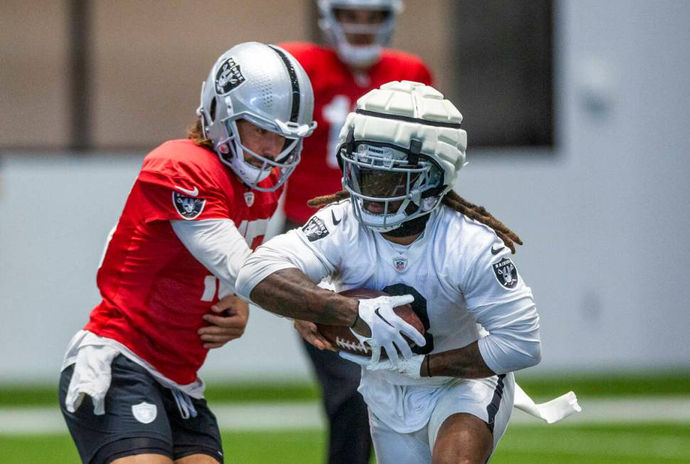 Raiders quarterback Gardner Minshew (15) hands off to Raiders running back Ameer Abdullah (8) d ...