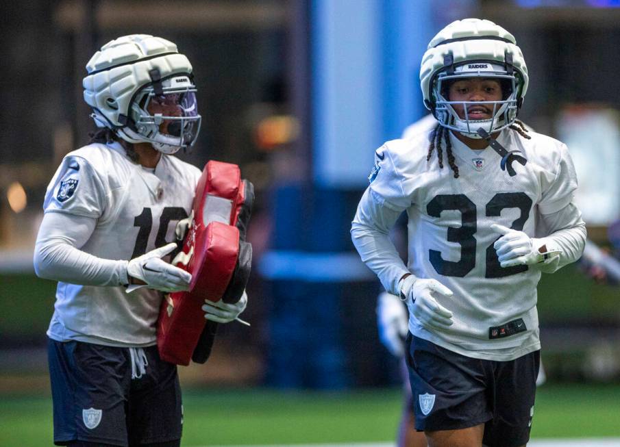 Raiders wide receiver DJ Turner (19) looks to wide receiver Tyreik McAllister (32) on a drill d ...