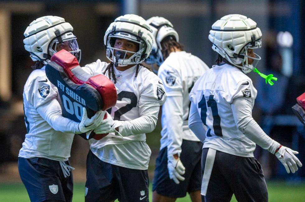 Raiders wide receiver DJ Turner (19) looks to wide receiver Tyreik McAllister (32) on a drill d ...