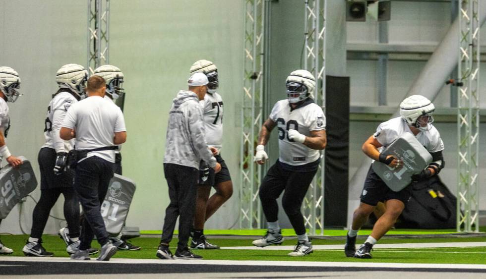 Raiders guard Jackson Powers-Johnson (70), right, runs a blocking drill with teammates during p ...