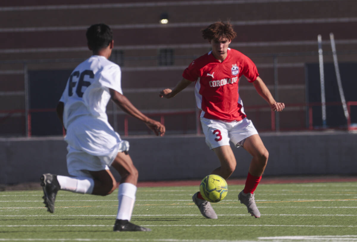 Coronado's Grayson Elisaldez (3) looks to kick the ball under pressure from Cimarron-Memorial d ...