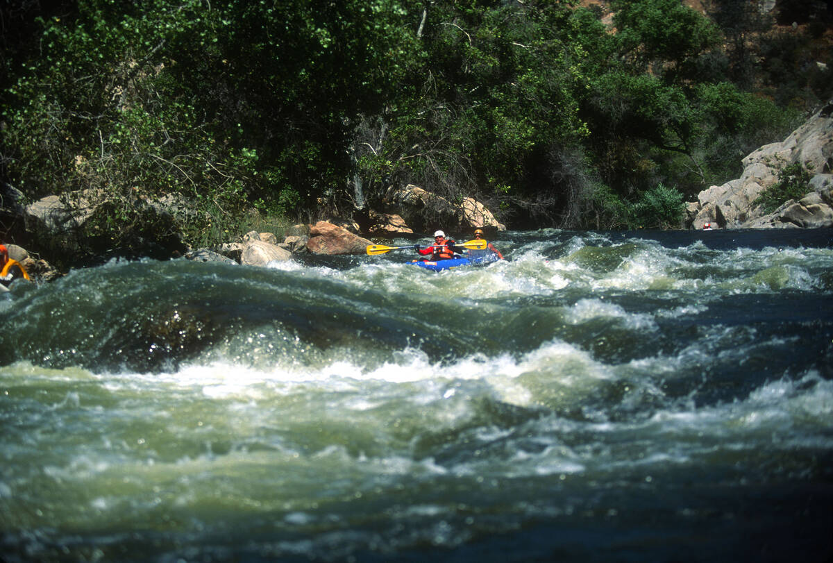 Scouting the rapids for whitewater riverboarding in the Kern River in the Sequoia National Fore ...