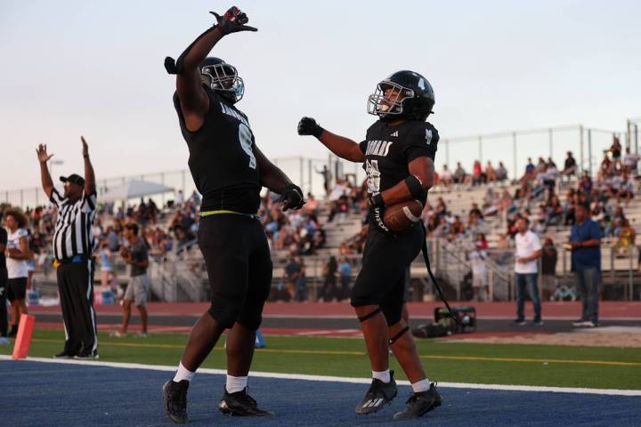 Desert Pines tight end Michael Taylor (9) and running back Isaiah Te'o (4) celebrate a tou ...