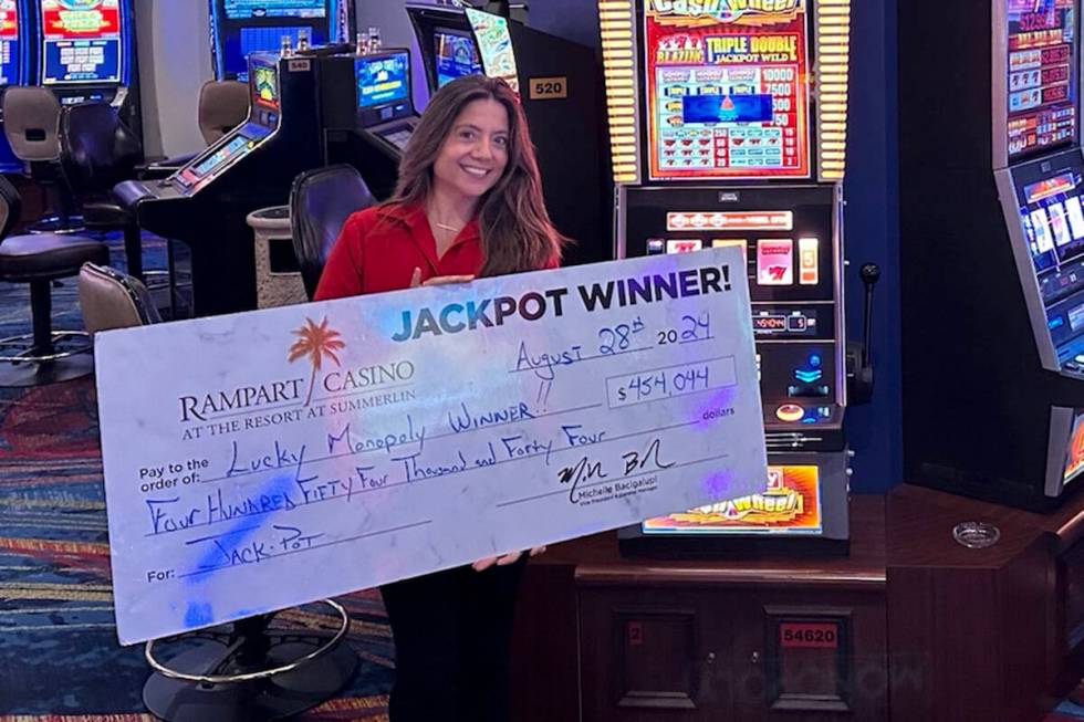 Rampart slot attendant Gabby Quiroga shares a $454,044 check after a slots player won on Monopo ...